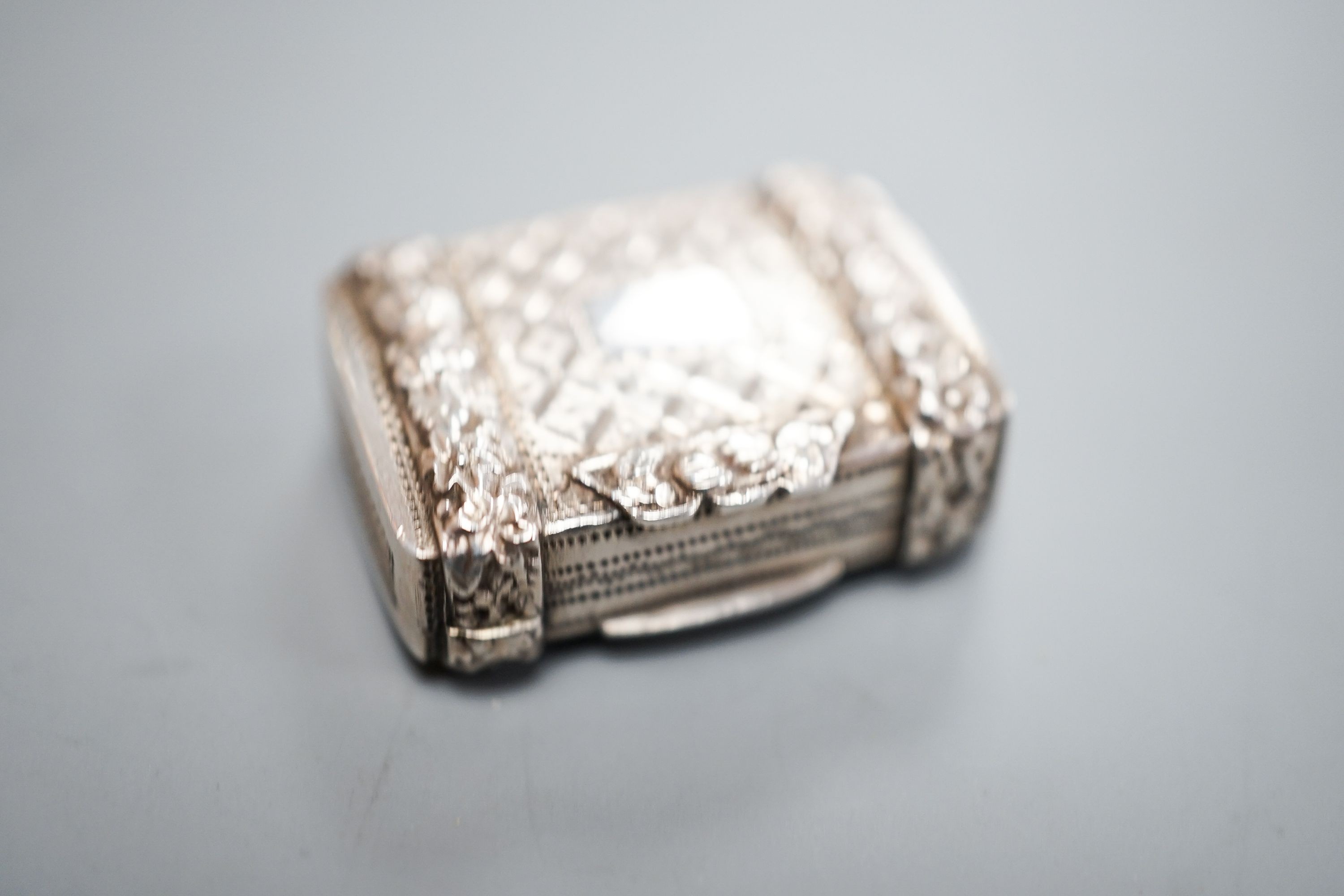 A George IV silver vinaigrette, by John Bettridge, with embossed flower head decoration, Birmingham, 1820, 26mm.
